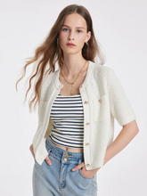 a lady in a beige pure cotton round neck knitted cardigan with a striped top and jeans